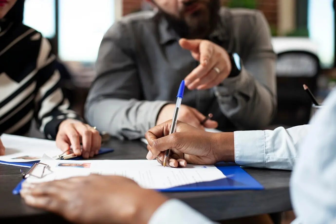 Schwarze Person unterschreibt einen Arbeitsvertrag.